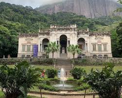 Parque Lage no Rio de Janeiro, edifício histórico cercado por vegetação exuberante e montanhas ao fundo